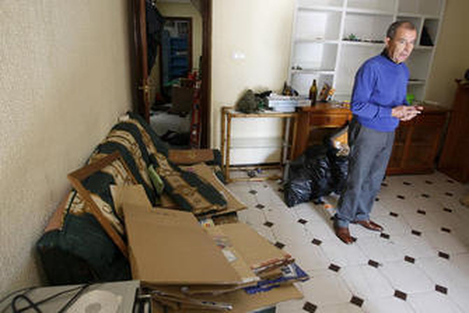 El propietario aparece en la sala de estar con el sofá lleno de objetos y bolsas y botellas en el habitáculo.