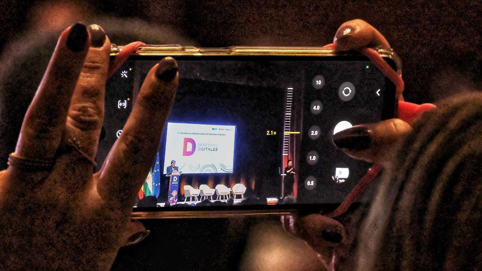 Una de las asistentes a la Jornada de Reflexión sobre Derechos Digitales celebrada en San Fernando fotografía con su teléfono móvil la intervención del ministro José Luis Escrivá.