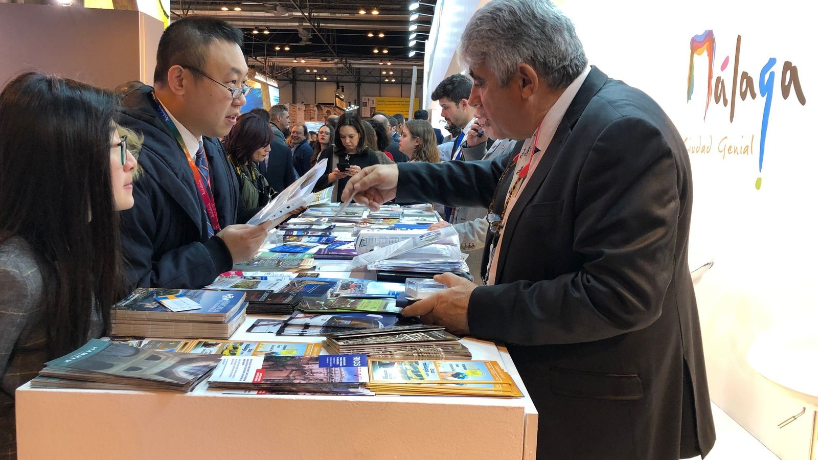 Dos turistas japoneses se informan en el expositor de Málaga