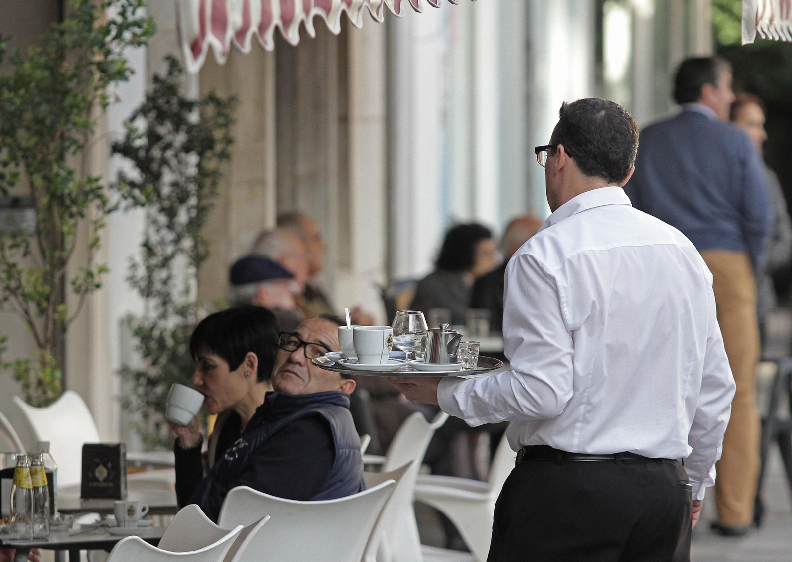 Un camarero atiende una terraza en Algeciras. Un camarero atiende una terraza en Algeciras.