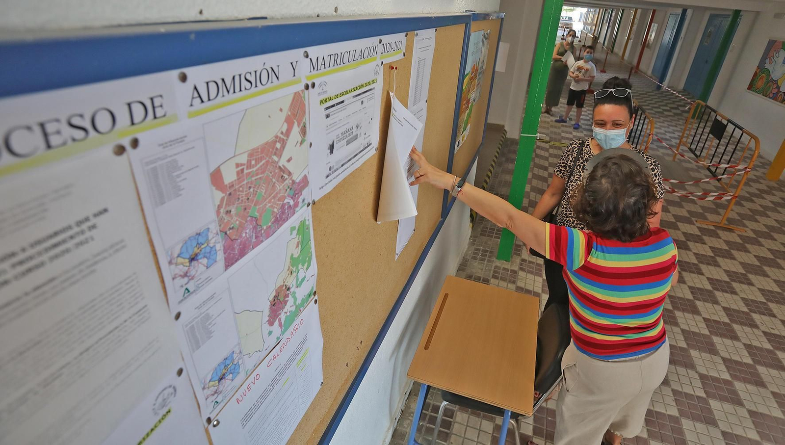 Dos personas, consultando las listas baremadas.