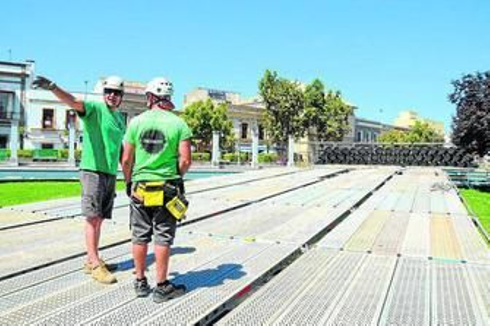 Dos operarios dialogan en la Plaza del Mamelón, escenario de la salida de la Vuelta.