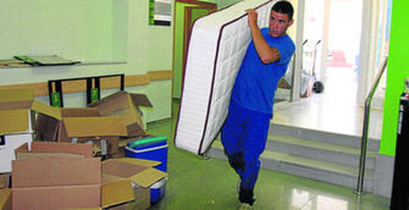 Uno de los trabajadores, entrando al centro de Tomás del Valle con un colchón parte del equipamiento.