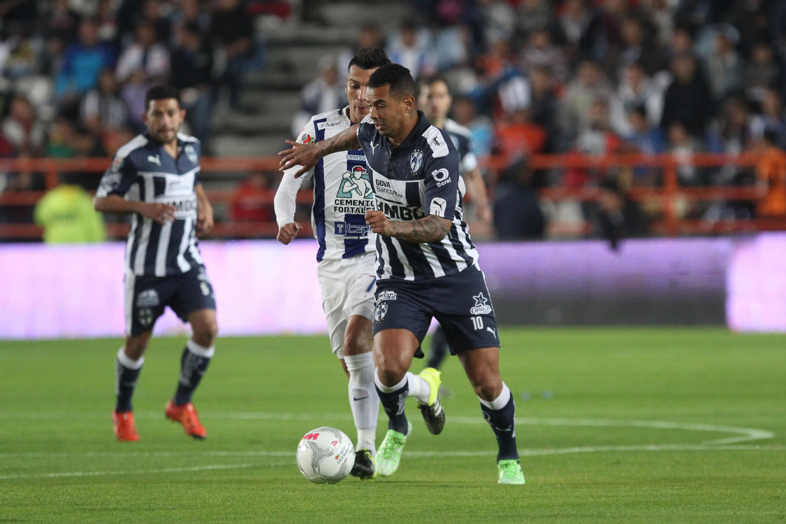 Cardona conduce el balón perseguido por Rubén Botta en un Pachuca-Monterrey.