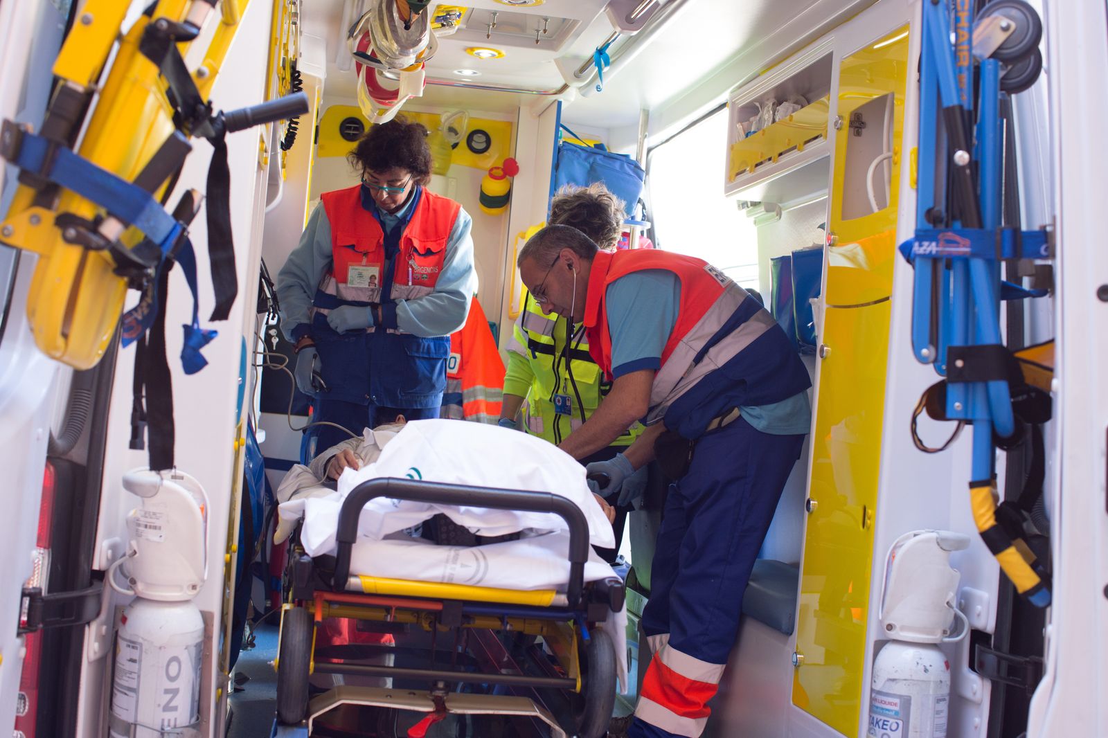 Dos profesionales de cuidados críticos y urgencias del Área de Gestión Sanitaria Sur de Sevilla atienden a un paciente en una ambulancia.