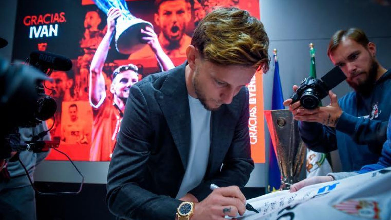 Rakitic firma una camiseta del Sevilla en su despedida.