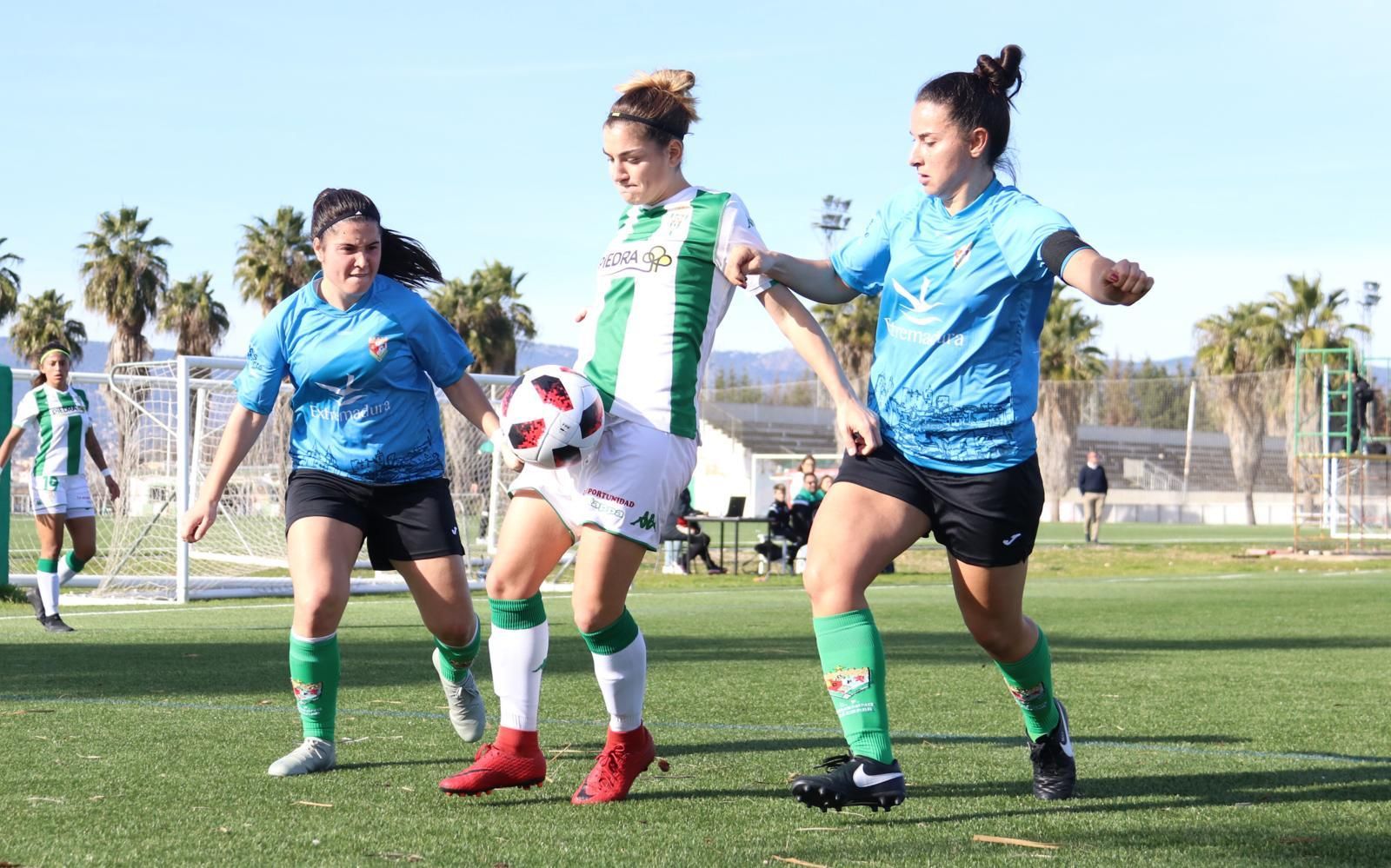 Una jugadora del Córdoba trata de salir con el balón entre dos jugadoras del Cáceres.
