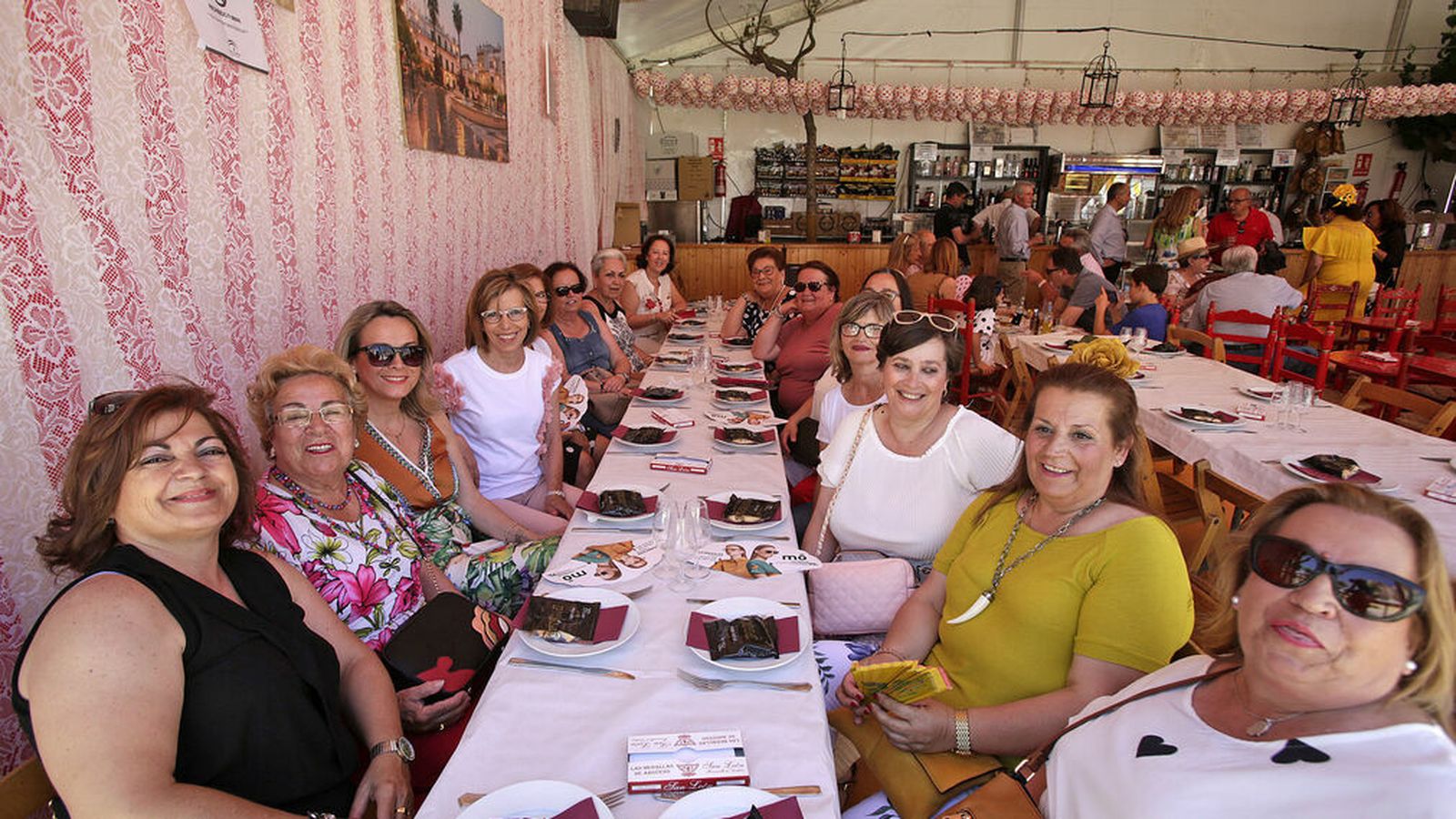 Un grupo numeroso de sanluqueñas preparadas para almorzar en una caseta de la Feria de la Manzanilla.