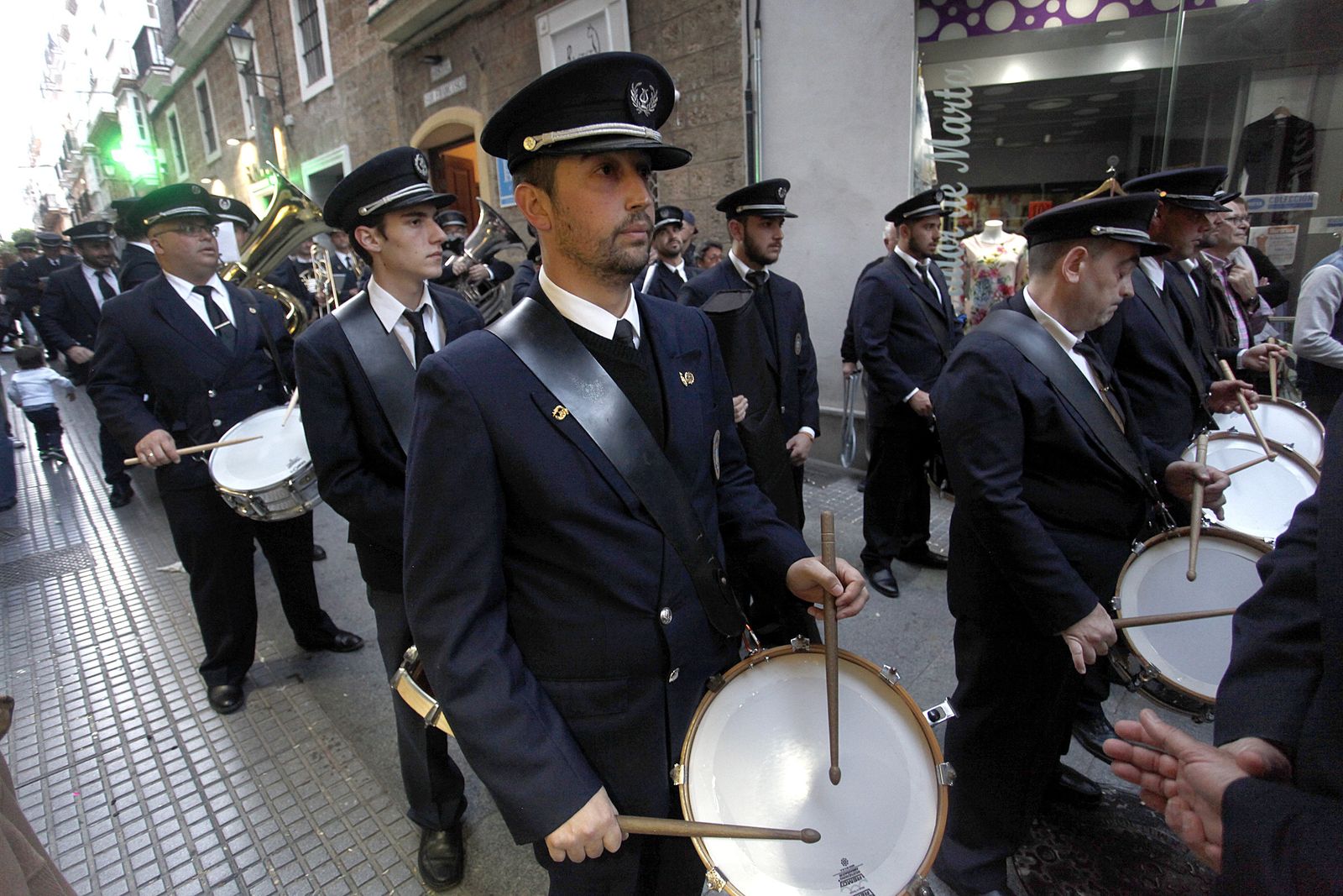 Miembros de la Banda de Música Enrique Montero de Chiclana, procesiona tras el paso de la Vera-Cruz.