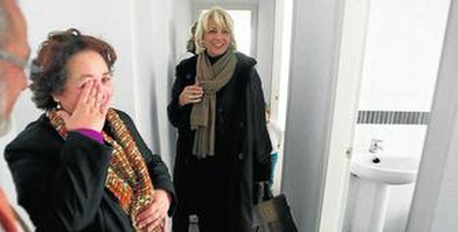 Una inquilina llora en presencia de Teófila Martínez tras recibir su piso.