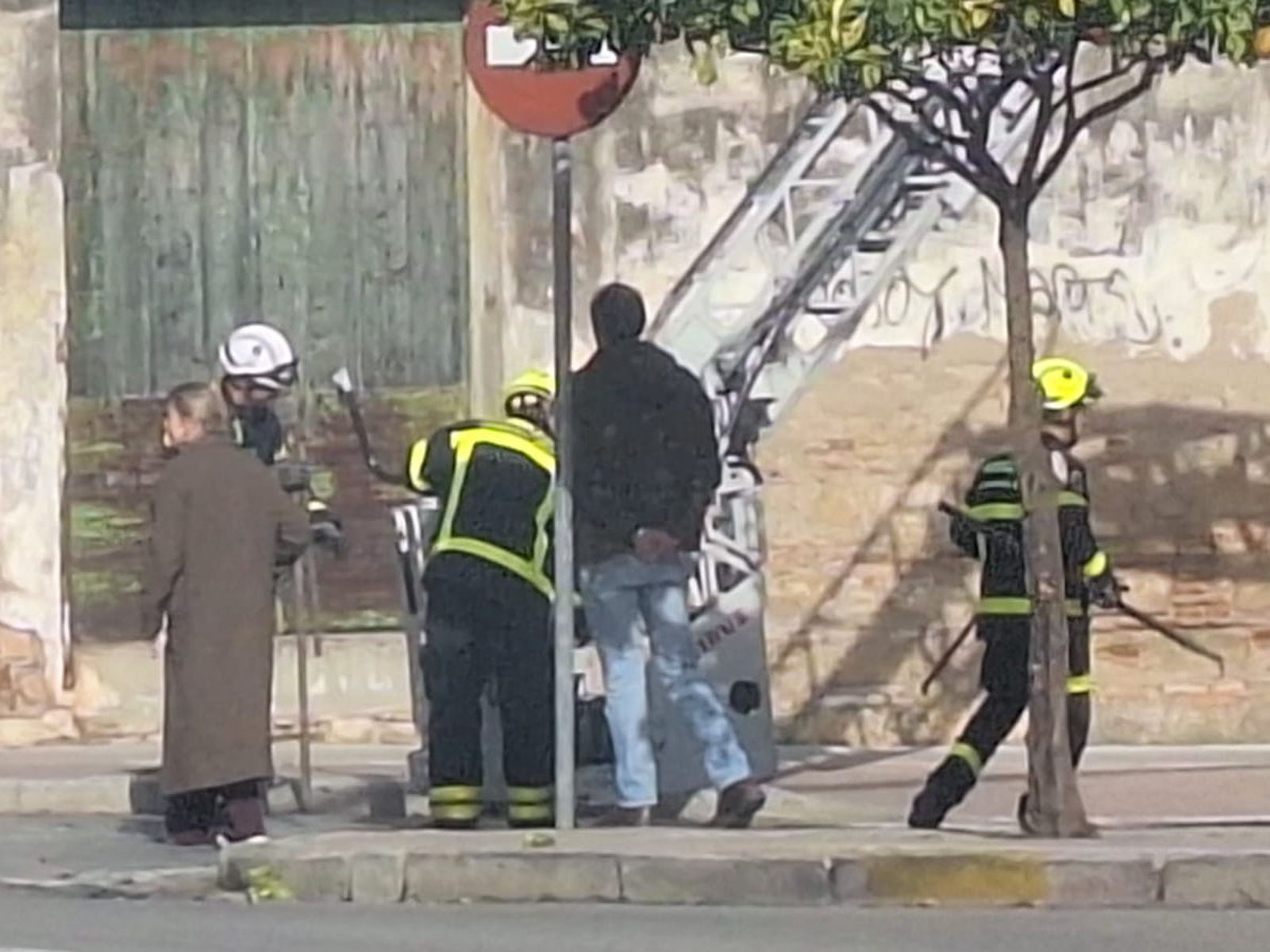 Bomberos junto a la pared de la bodega.