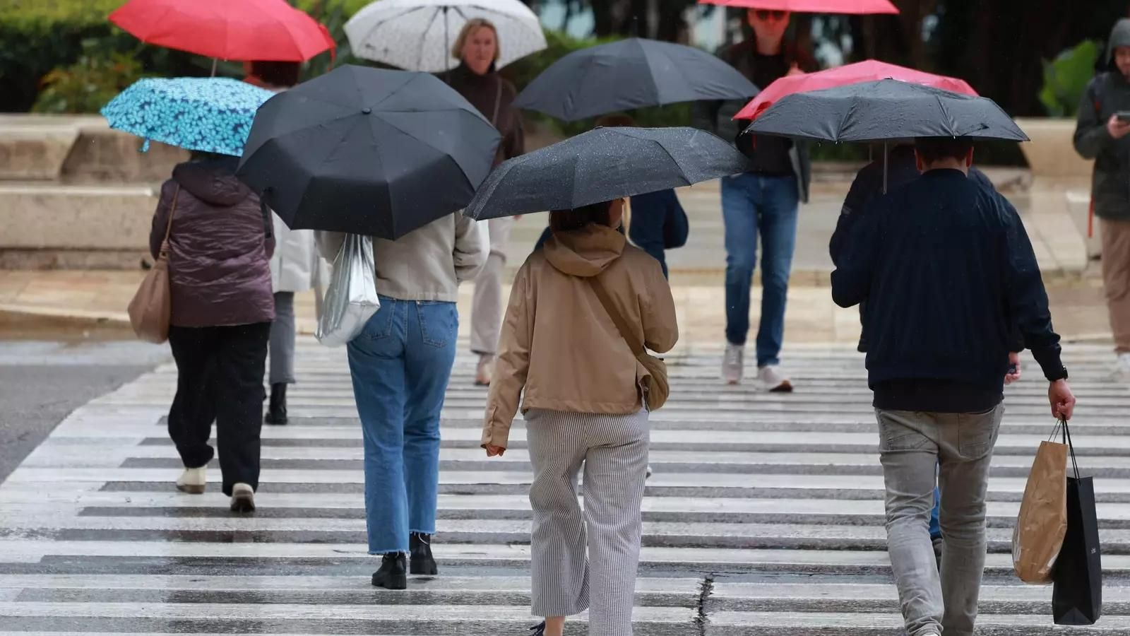 Malagueños caminando con paraguas