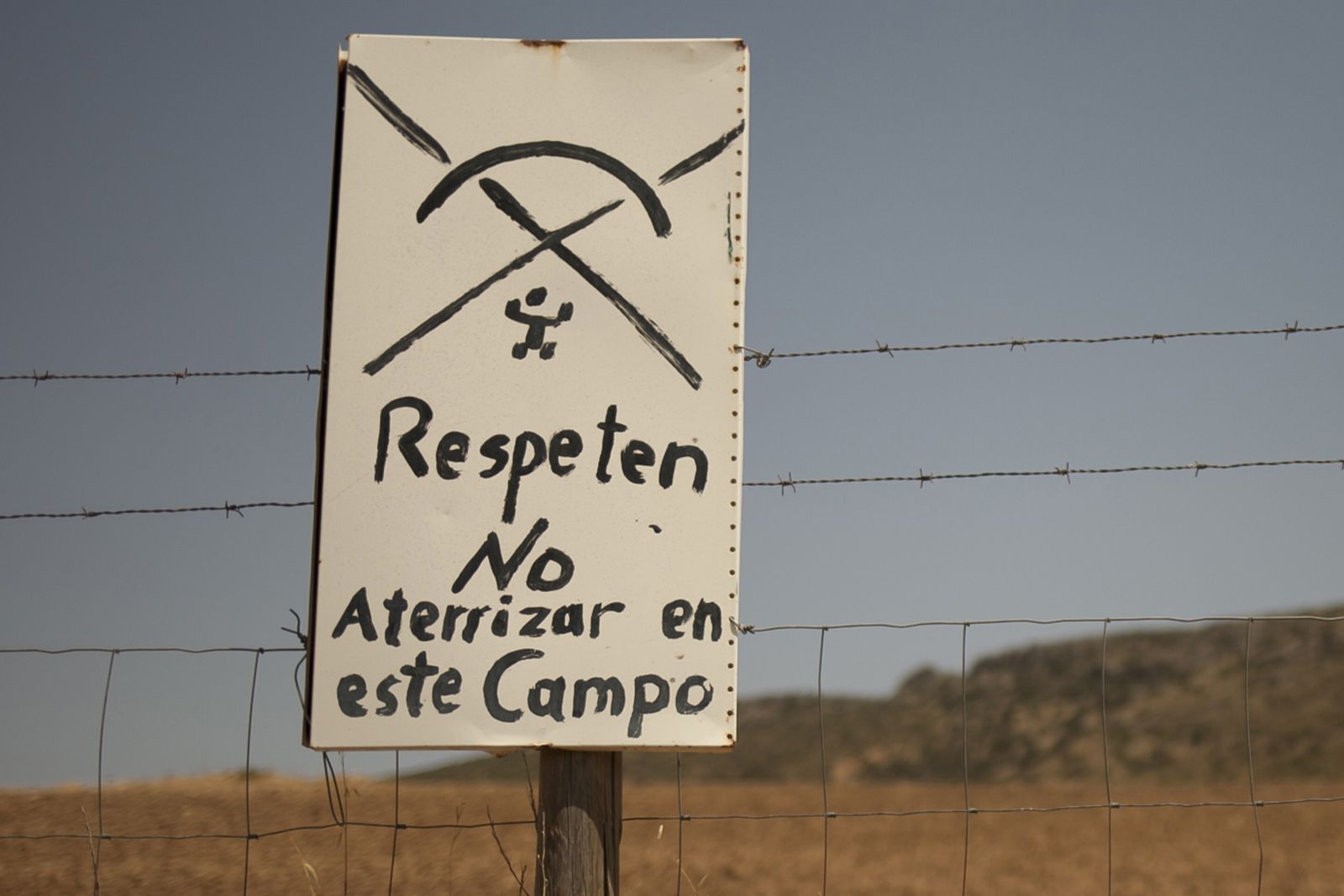 Cartel, previsiblemente colocado por un particular, para que los parapentistas no aterricen en su finca.