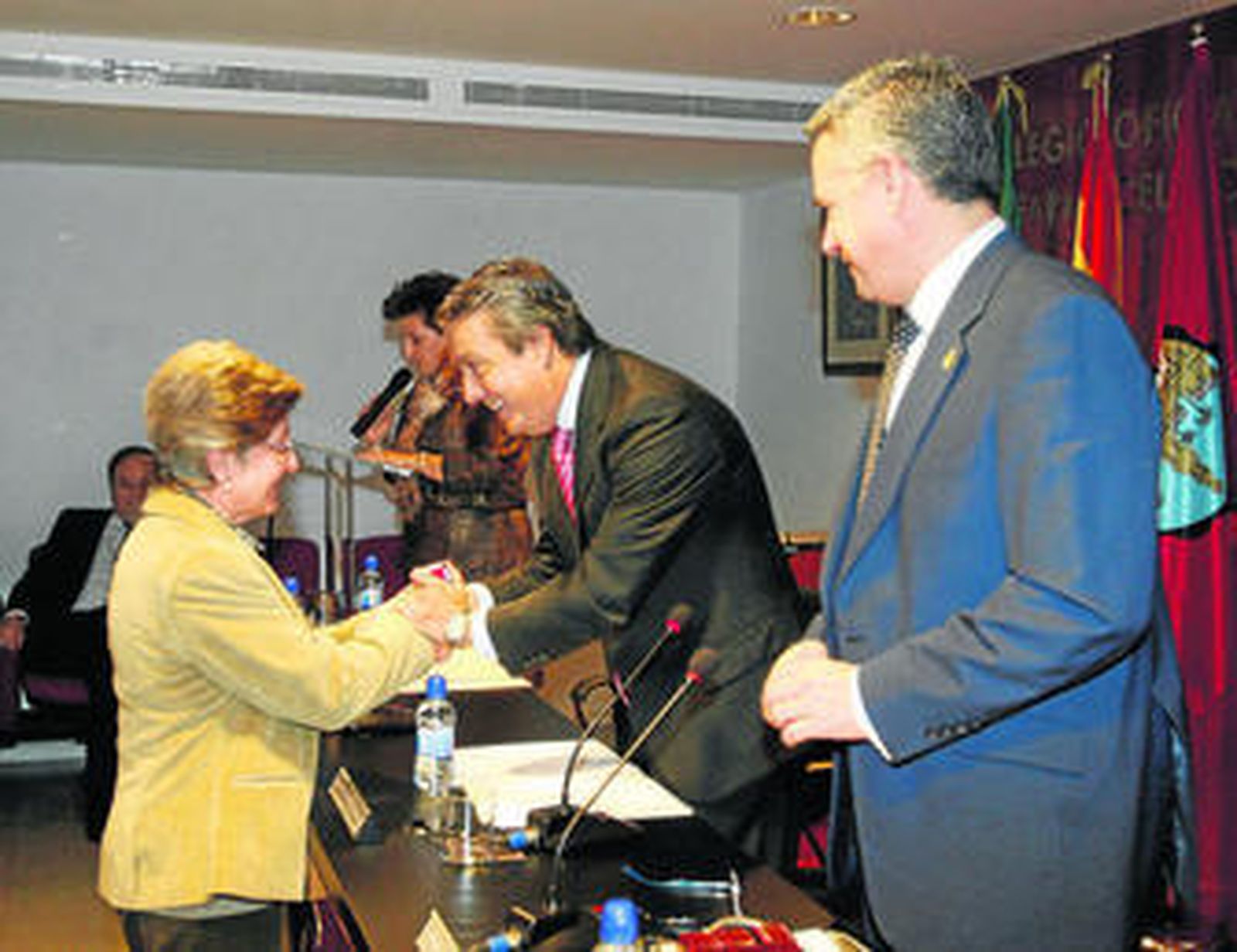 Práxedes Cruz otorga la insignia a una farmacéutica.