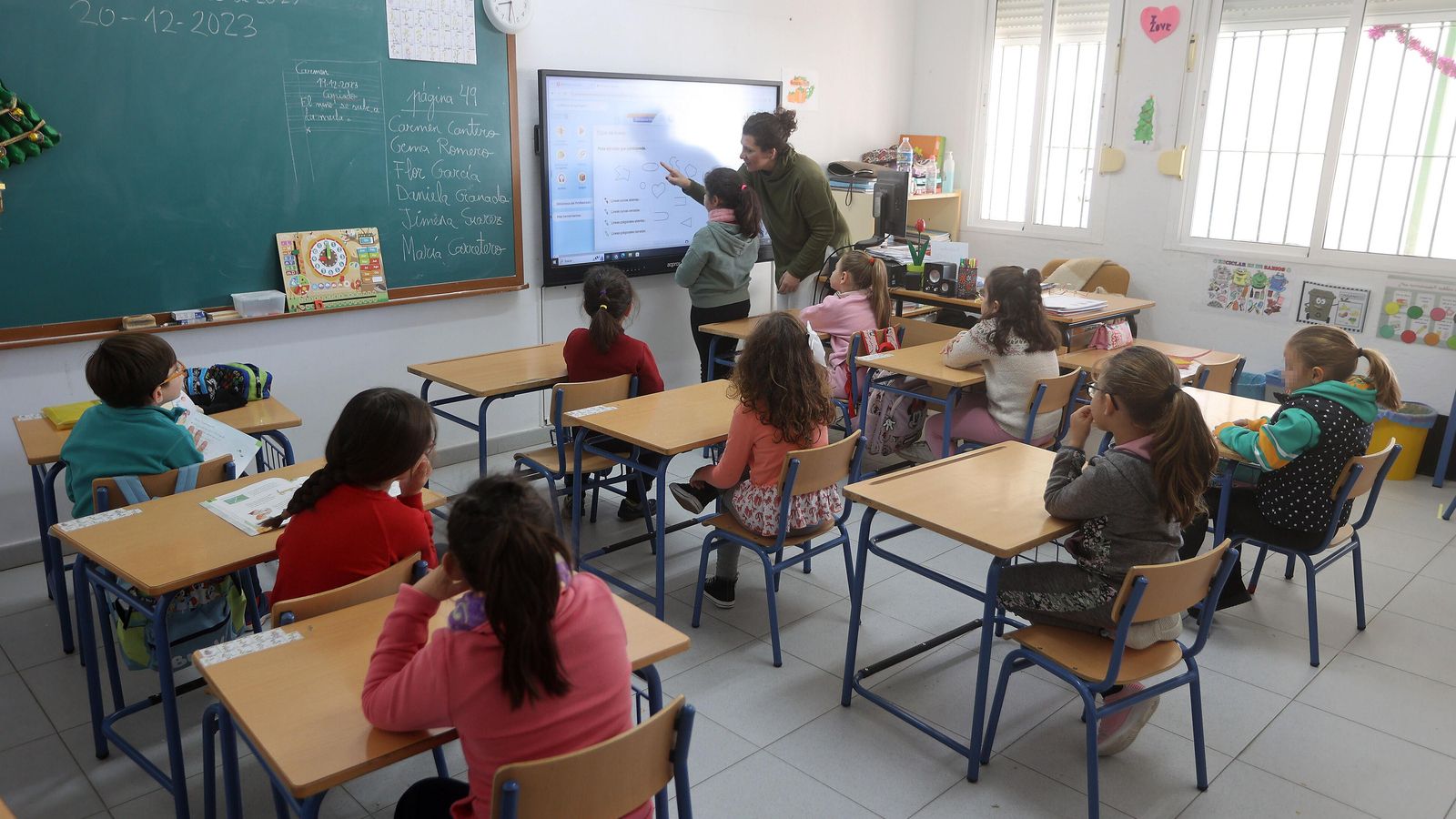 María Dolores Amores muestra  unos pictogramas en la pizarra digital de un aula con alumnos de seis y siete años.