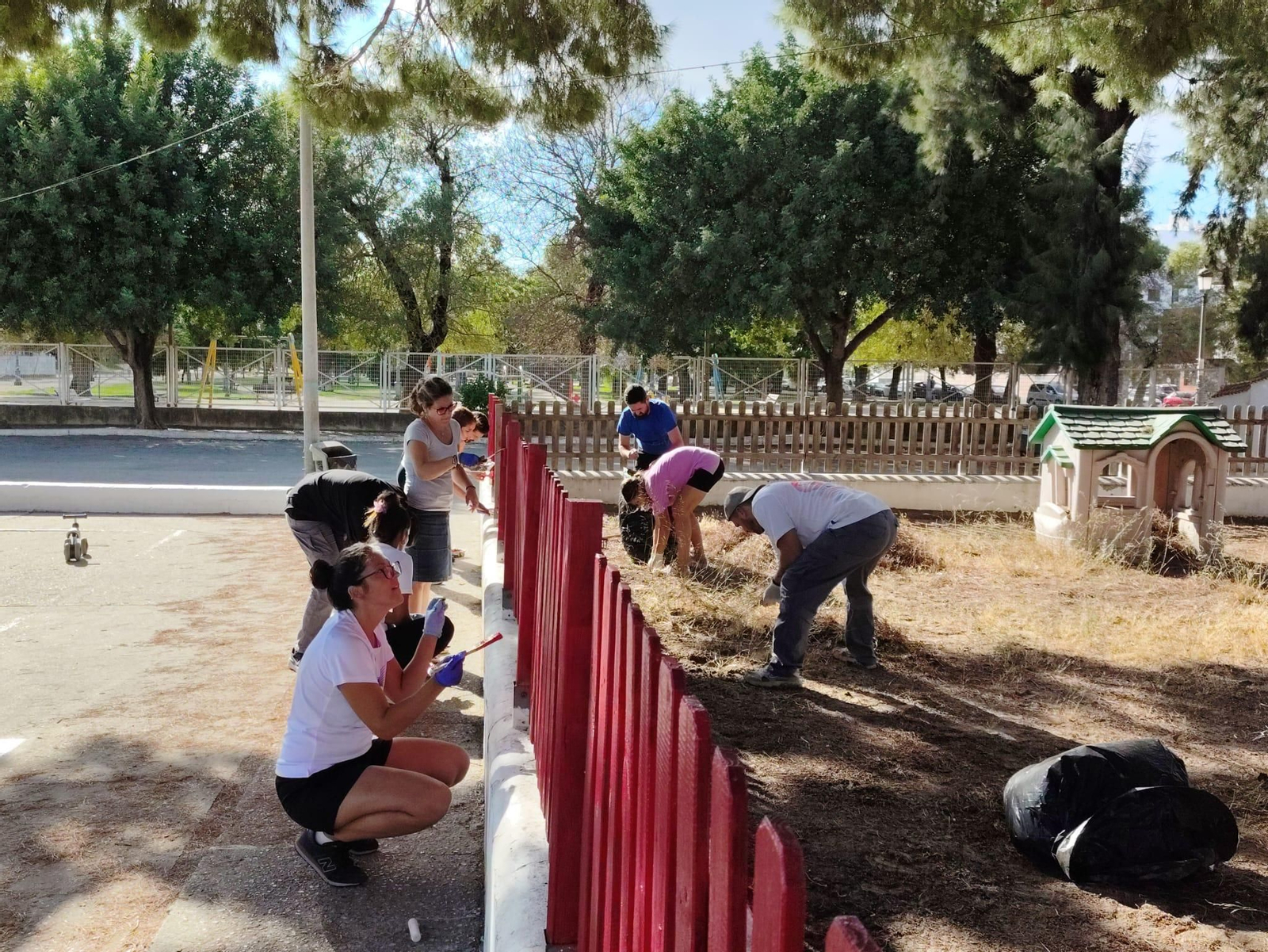 Padres y madres del alumnado del CEIP El Retiro pintando la valla del centro y adecentando el arenero. (Jerez).