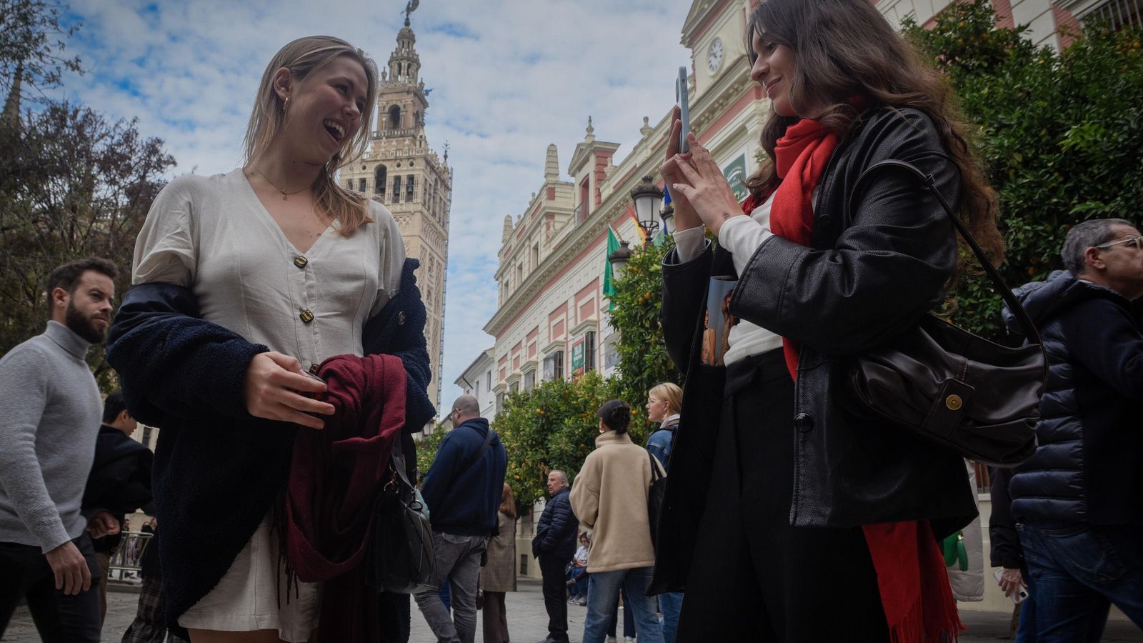 Una joven se hace una fotografía con la Giralda al fondo.