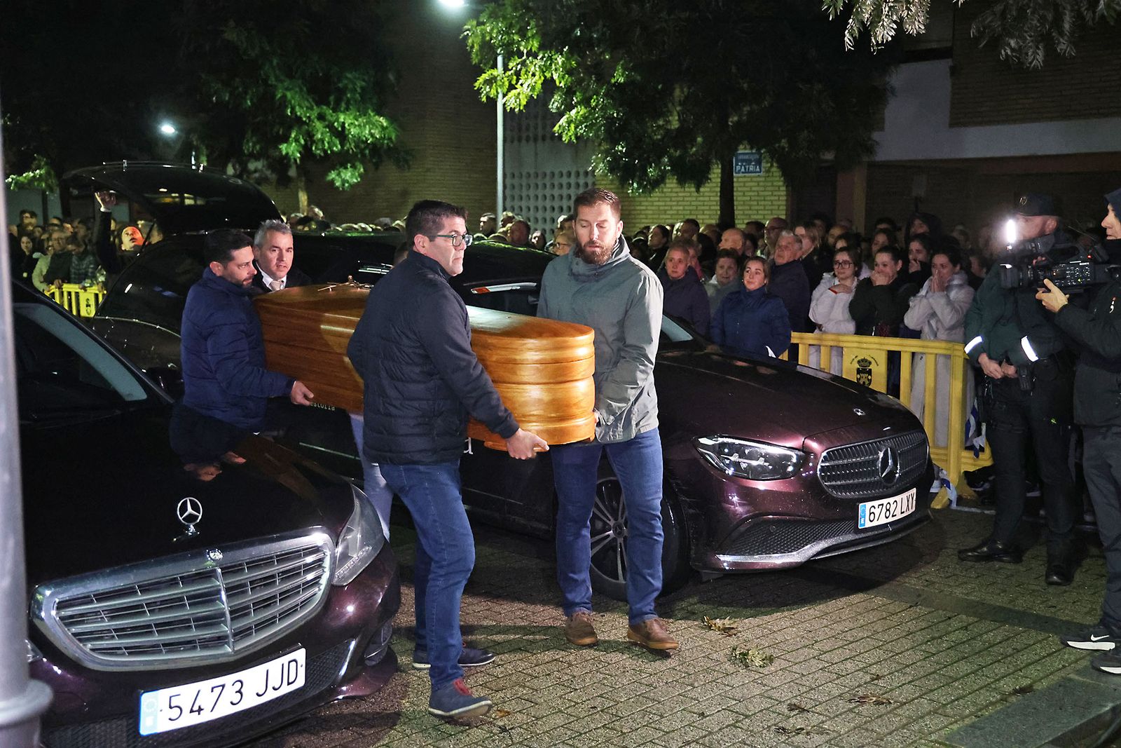 Vecinos y amigos portan uno de los féretros de los cuatro miembros de la familia Zamorano Álvarez al interior del pabellón de deportes de Aljaraque, donde se instaló la capilla ardiente.