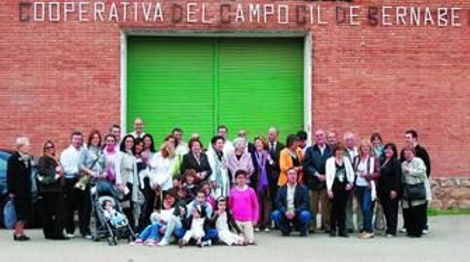 Los asistentes a la convivencia, en la fachada de la cooperativa de Báguena que lleva sus apellidos.