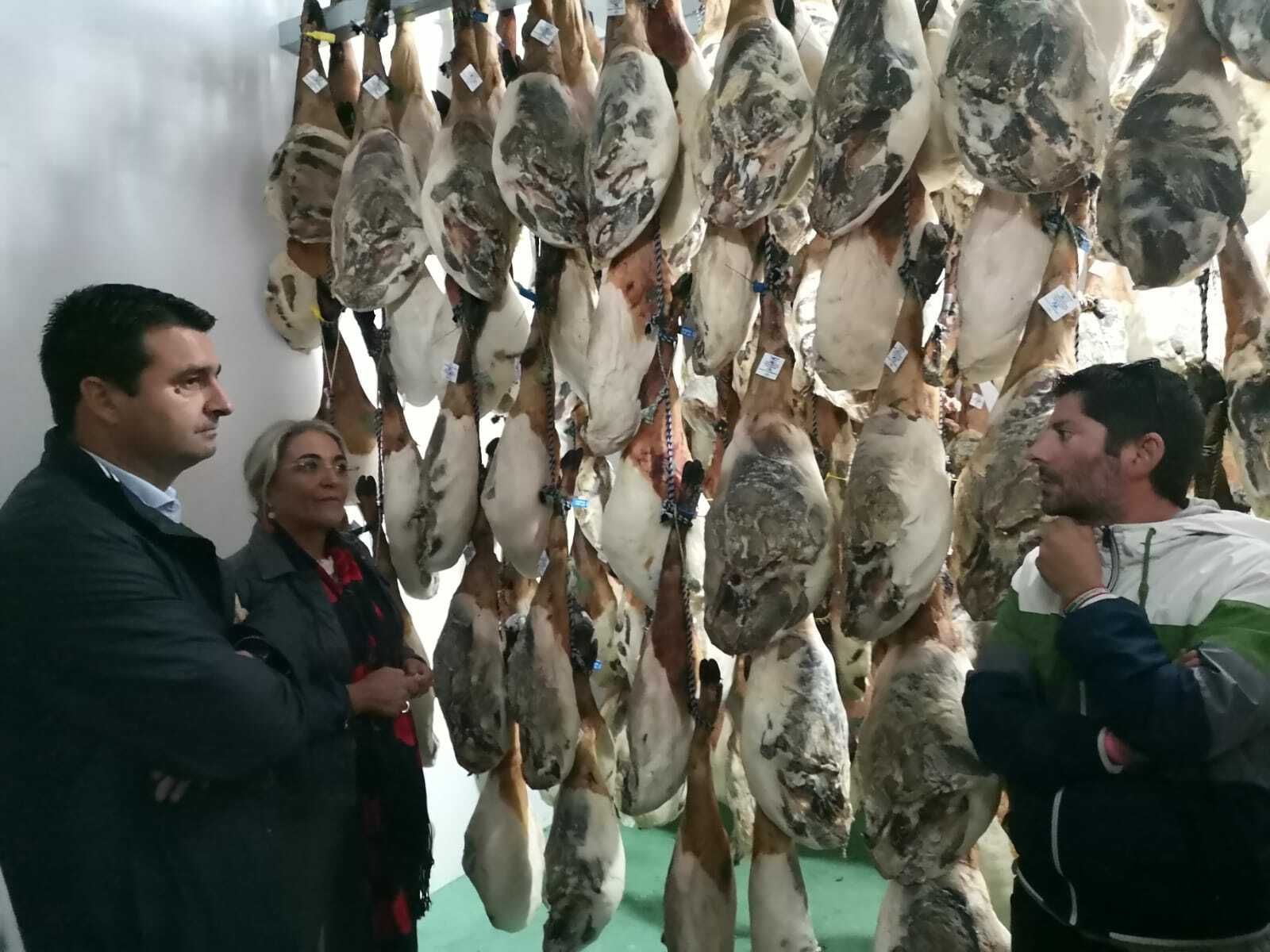 Amaro Huelva y Pepa González Bayo atienden a las explicaciones de un empresario cárnico.