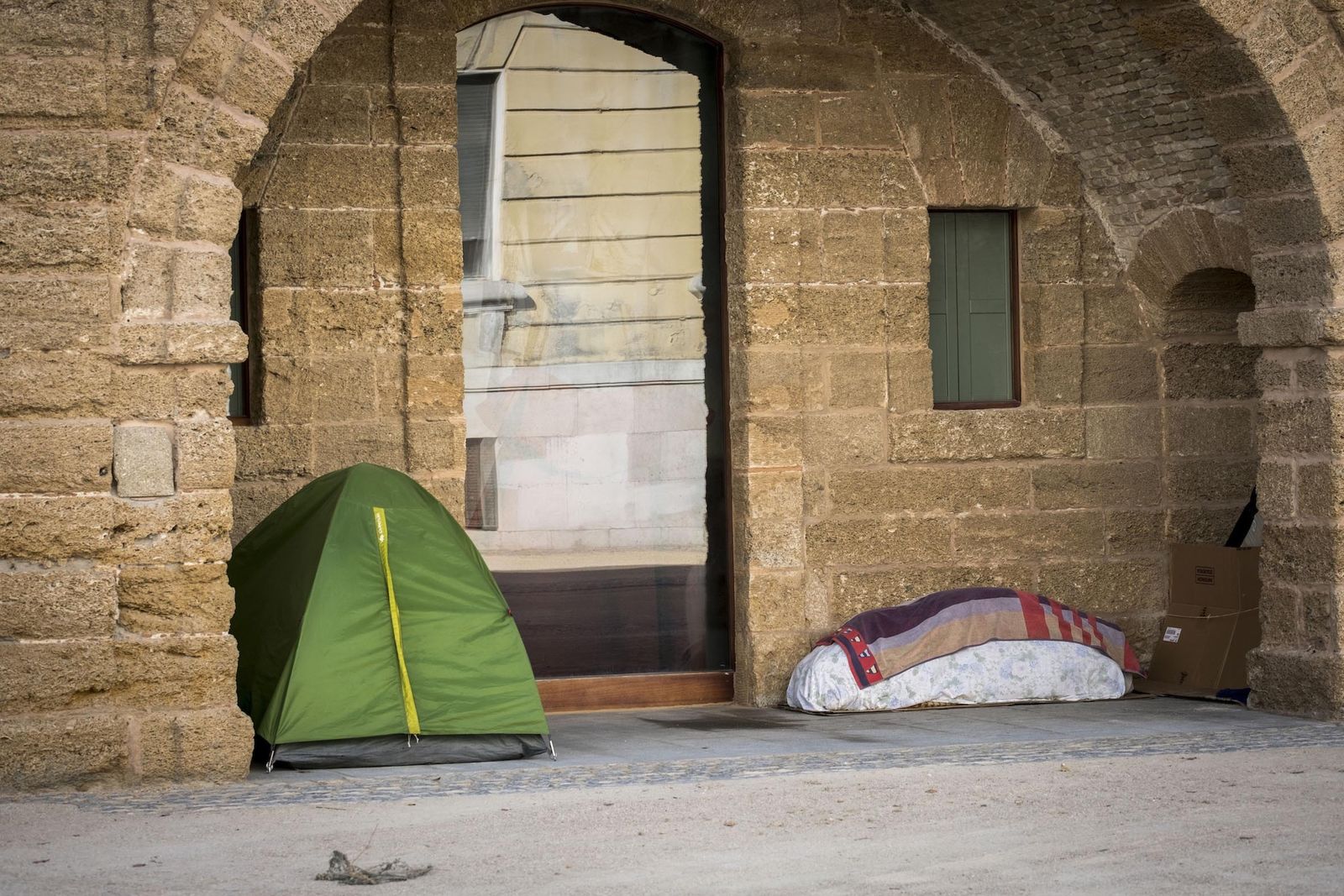 Una caseta de campaña y mantas bajo los arcos de las Puertas de Tierra.