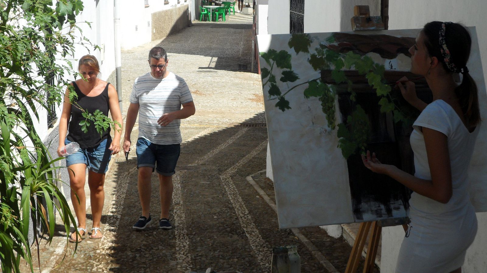 Una joven pinta su obra en una calle de Cortelazor.