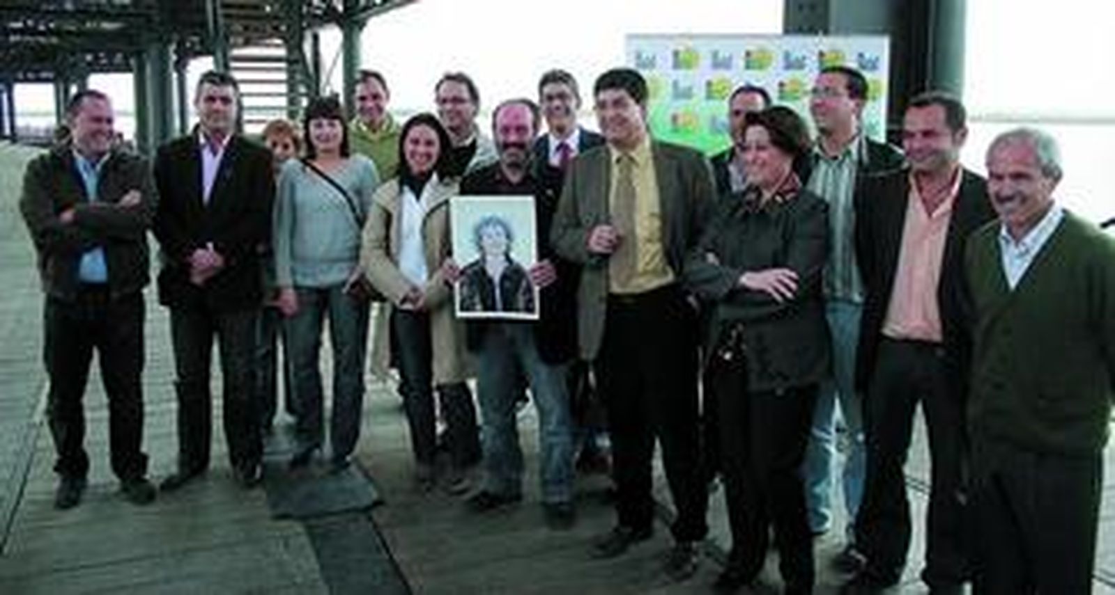 Los integrantes de las candidaturas de IU con la fotografía de uno de sus componentes en el  muelle cargadero del Tinto.