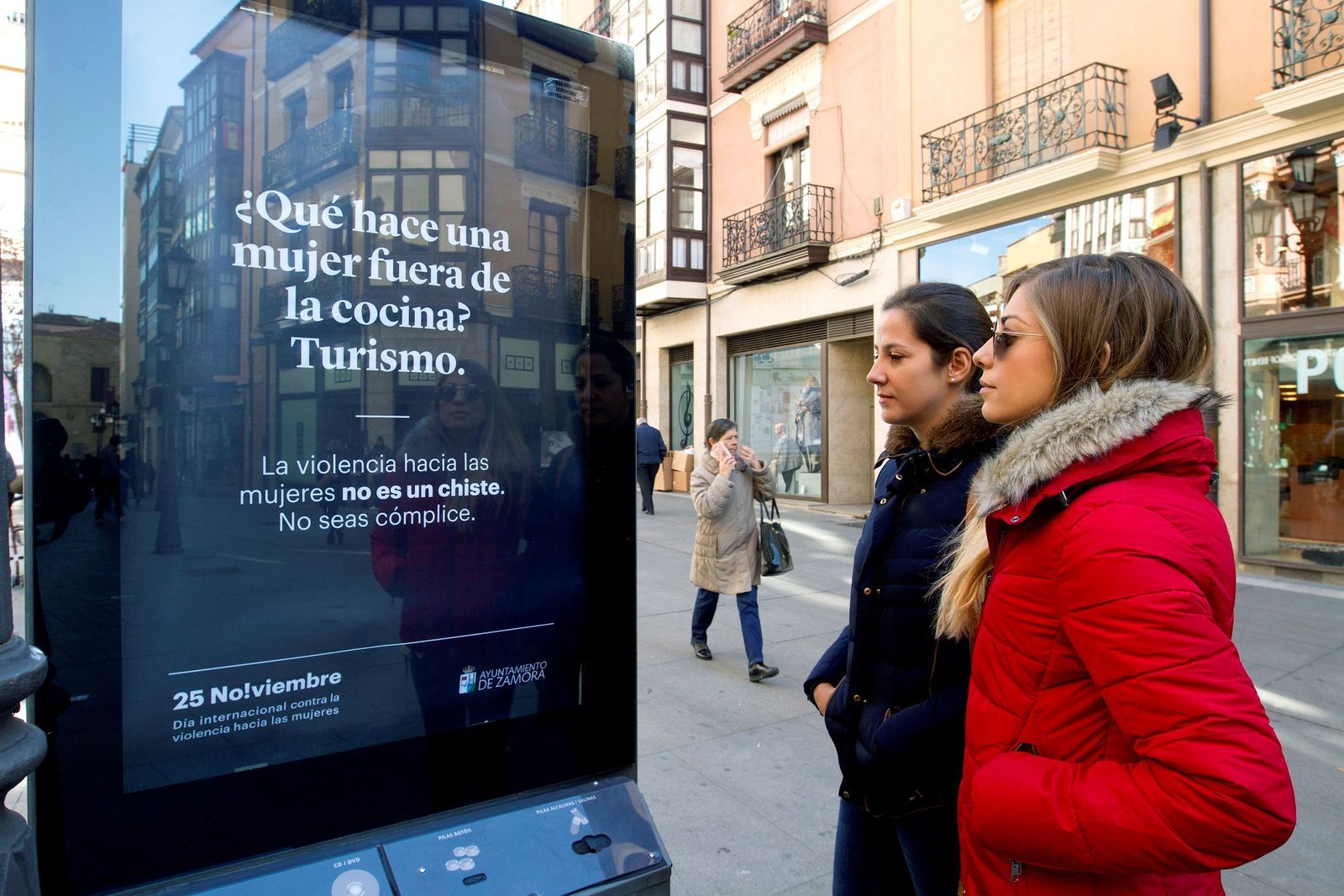 Dos mujeres observan uno de los carteles de la campaña contra la violencia machista del Ayuntamiento de Zamora.