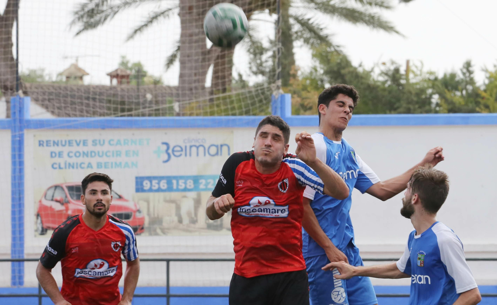 Pablo Giraldo salta más que un jugador del Cartaya con Selu Olmo, autor del gol, siguiendo la jugada.