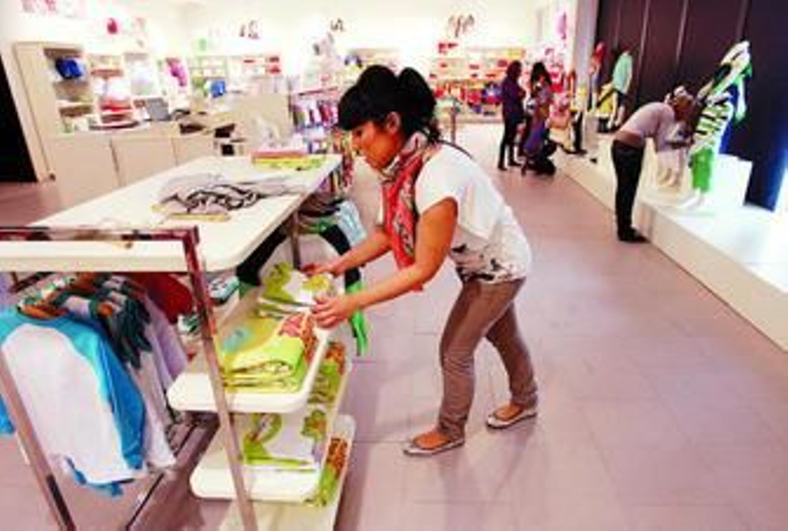 Varias empleadas colocan ropa en la tienda de formación de Charanga en el PTA.