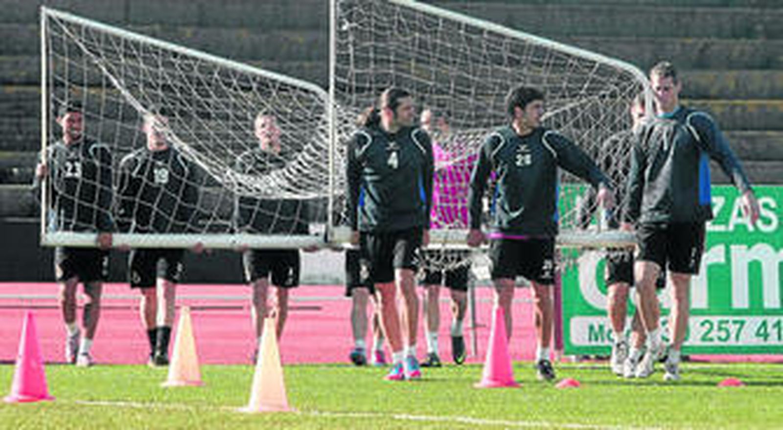 Jugadores de la Balona cargan una portería móvil durante el entrenamiento matinal de ayer.