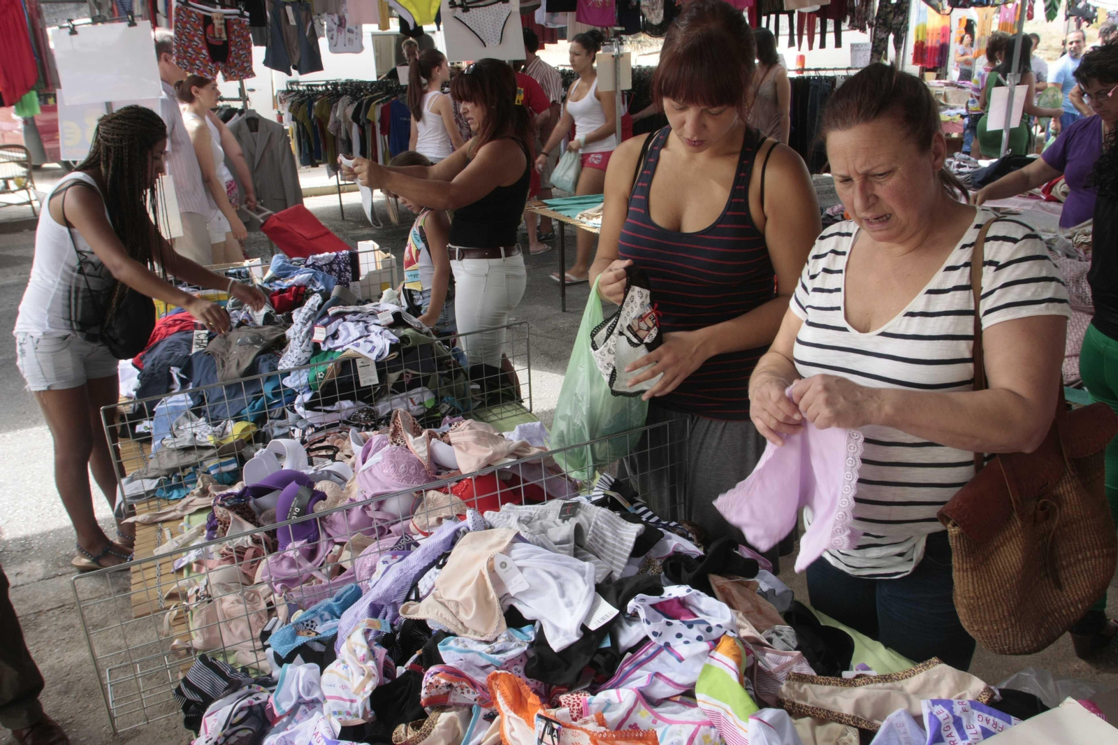 Varias mujeres compran en un puesto de ropa interior.