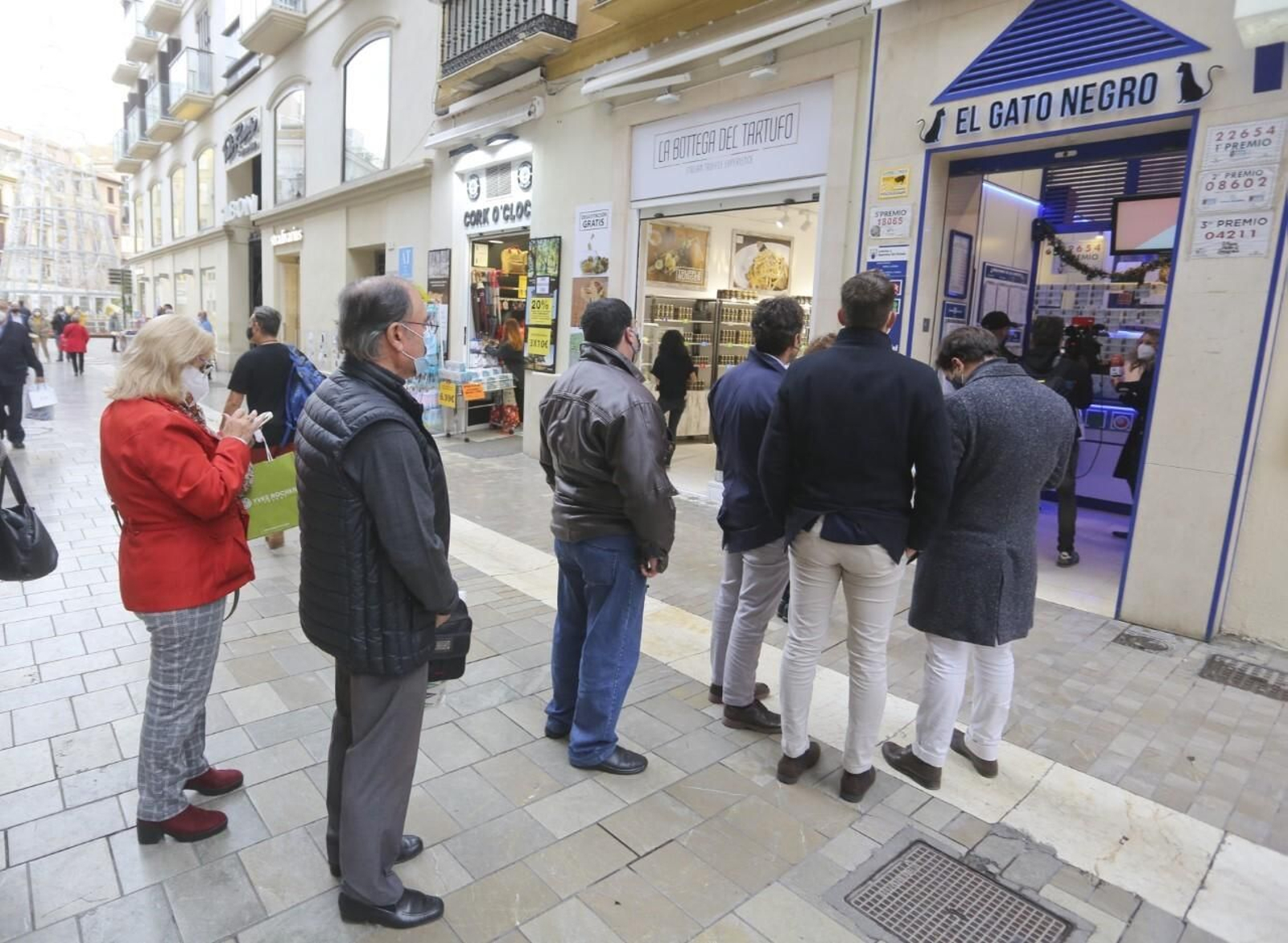 Varias personas hacen cola para comprar lotería de Navidad.