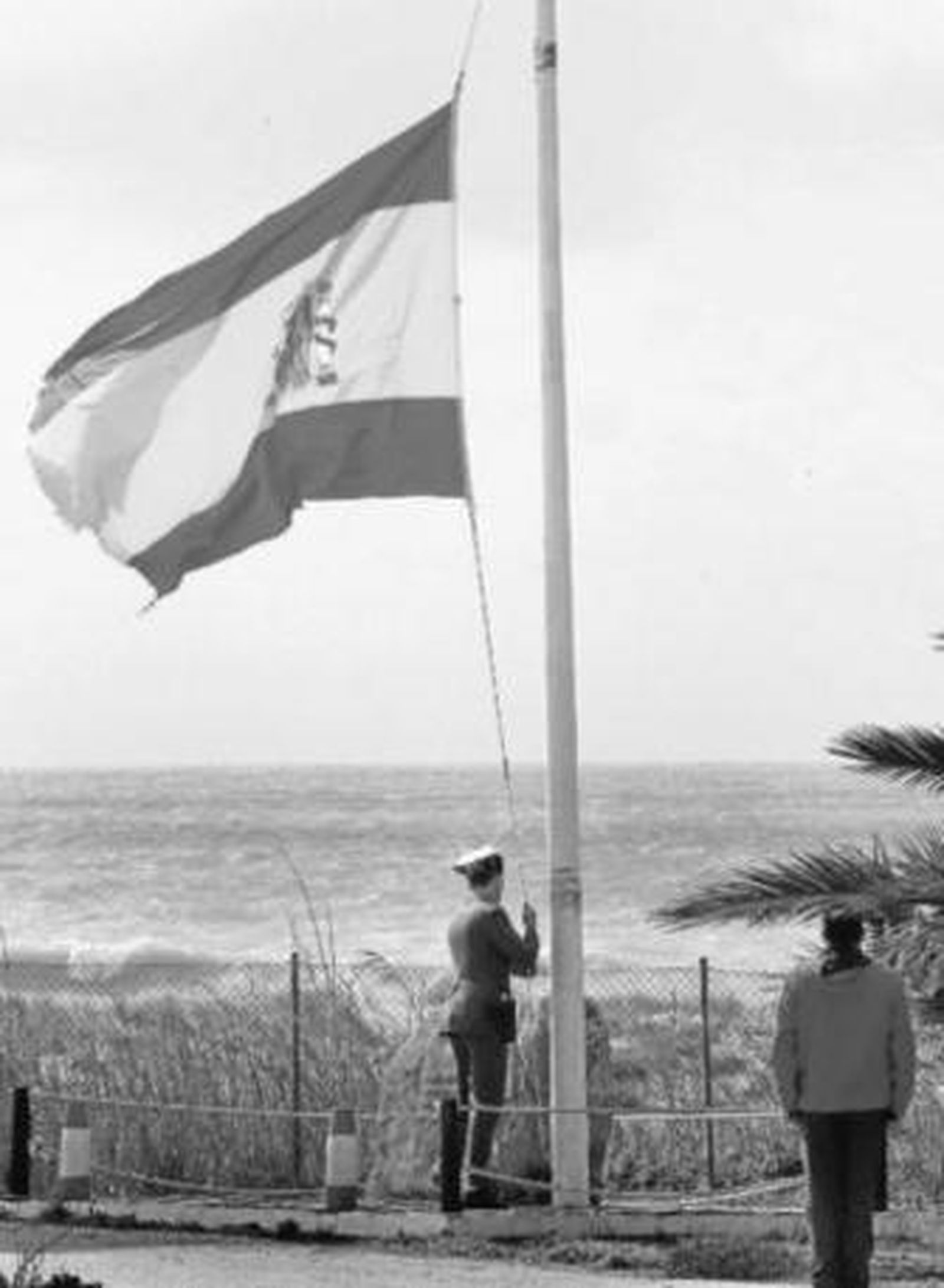 Un guardia civil arría la bandera española, ayer, a las dos de la tarde, en el cuartel de Torre Plata.