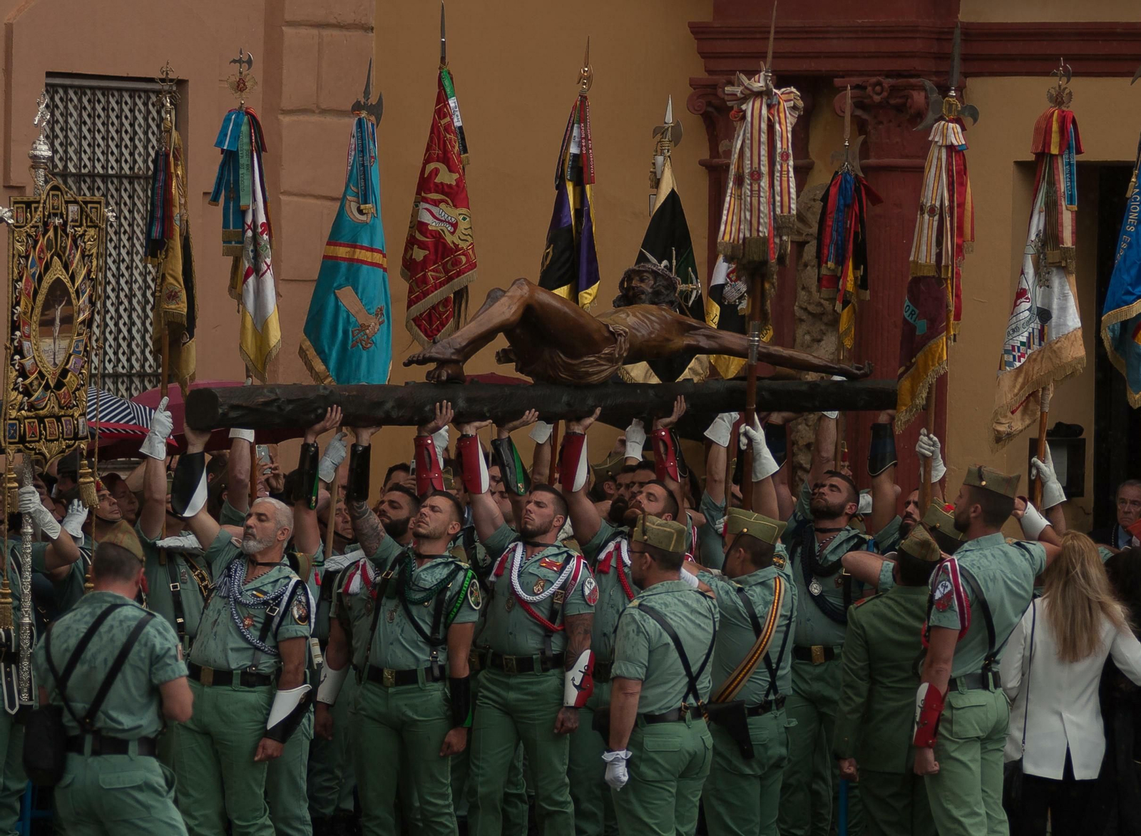 Legionarios portan al Cristo de Mena bajo la lluvia.