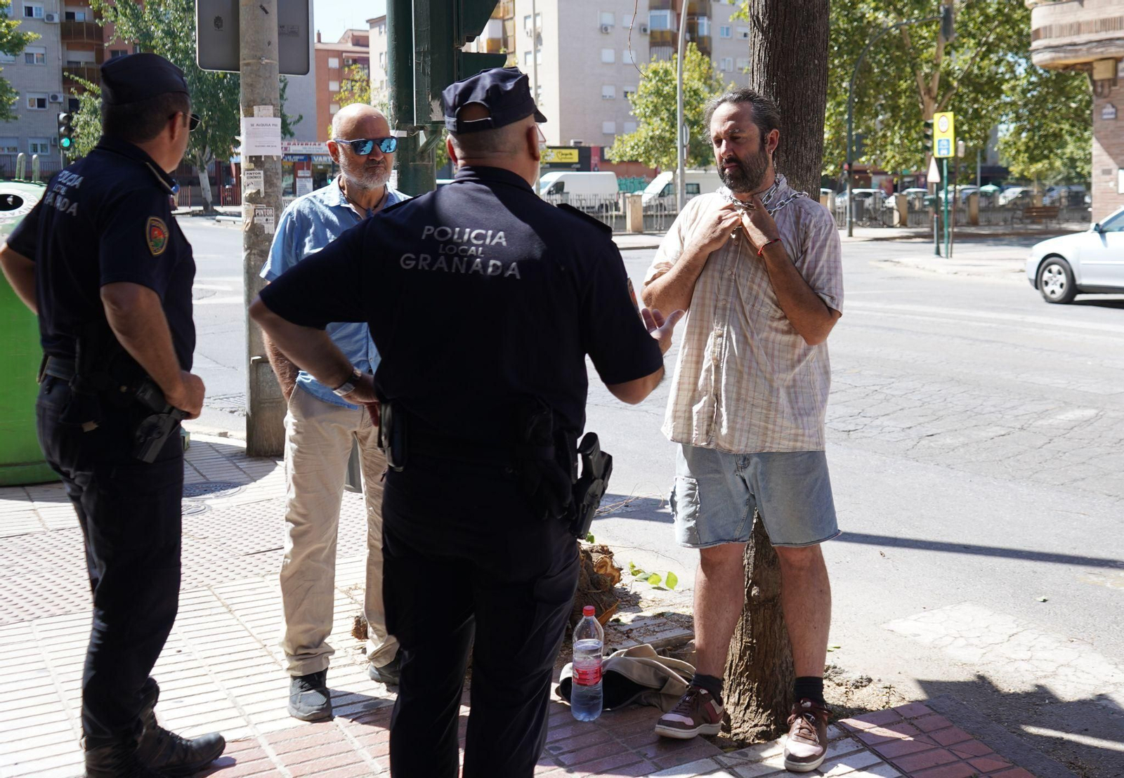 La Policía Local dialoga con el hombre encadenado en un árbol en la calle Arabial