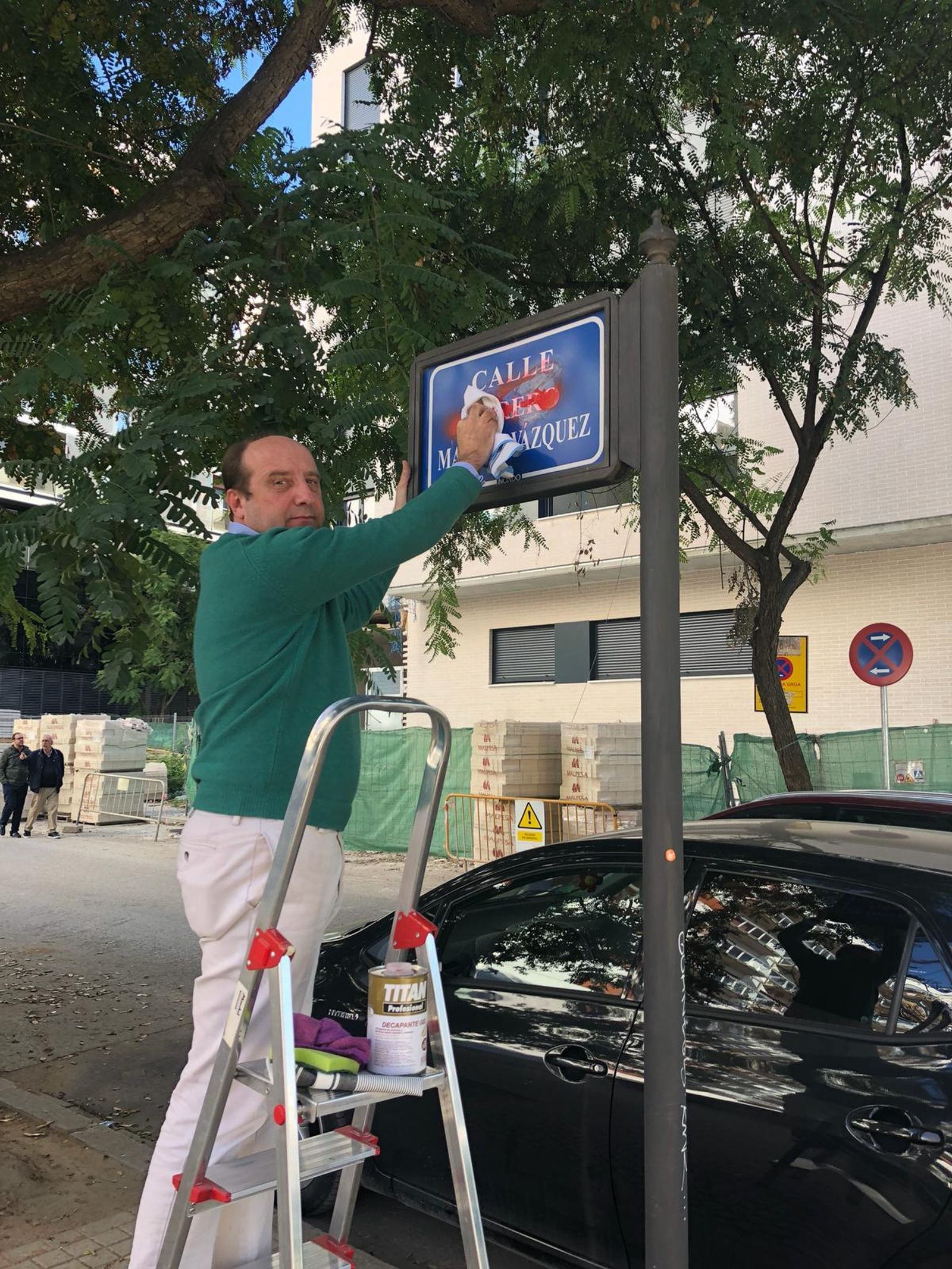 El abogado Joaquín Moeckel limpia el rótulo de la calle dedicada al torero Manolo Vázquez.