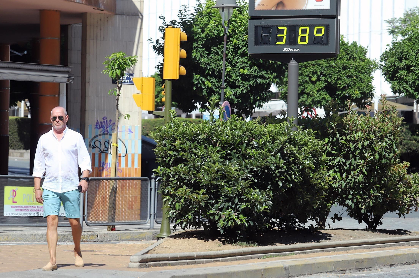 Un señor pasea por el centro de Huelva mientras que el termómetro marca 38 grados
