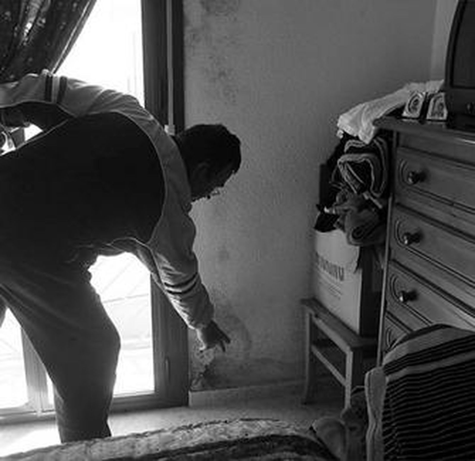 Leoncio Fernández muestra la pared de su casa, húmeda.