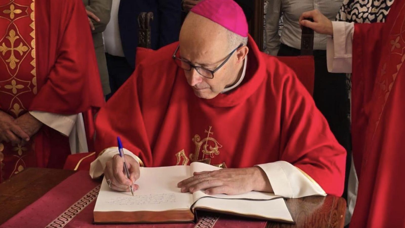 Monseñor Satué firmando el libro de visitas