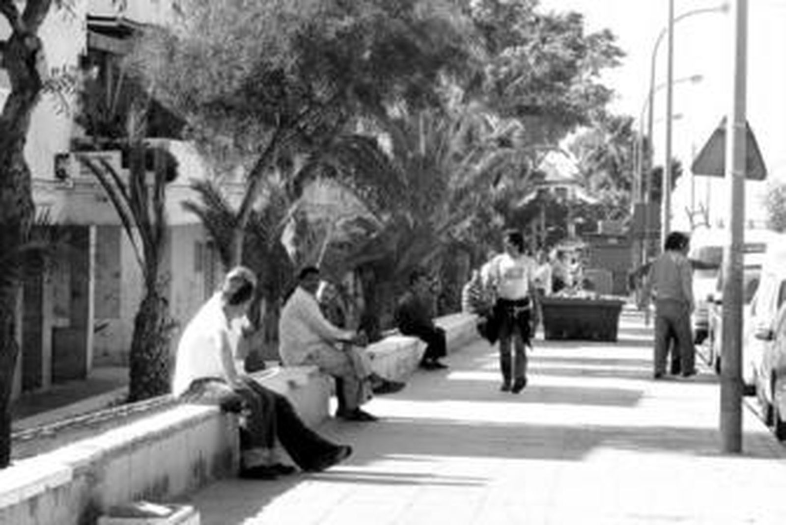 Vecinos del Puche pasean y descansan en la avenida Mare Nostrum a las diez de la mañana de un día de diario.