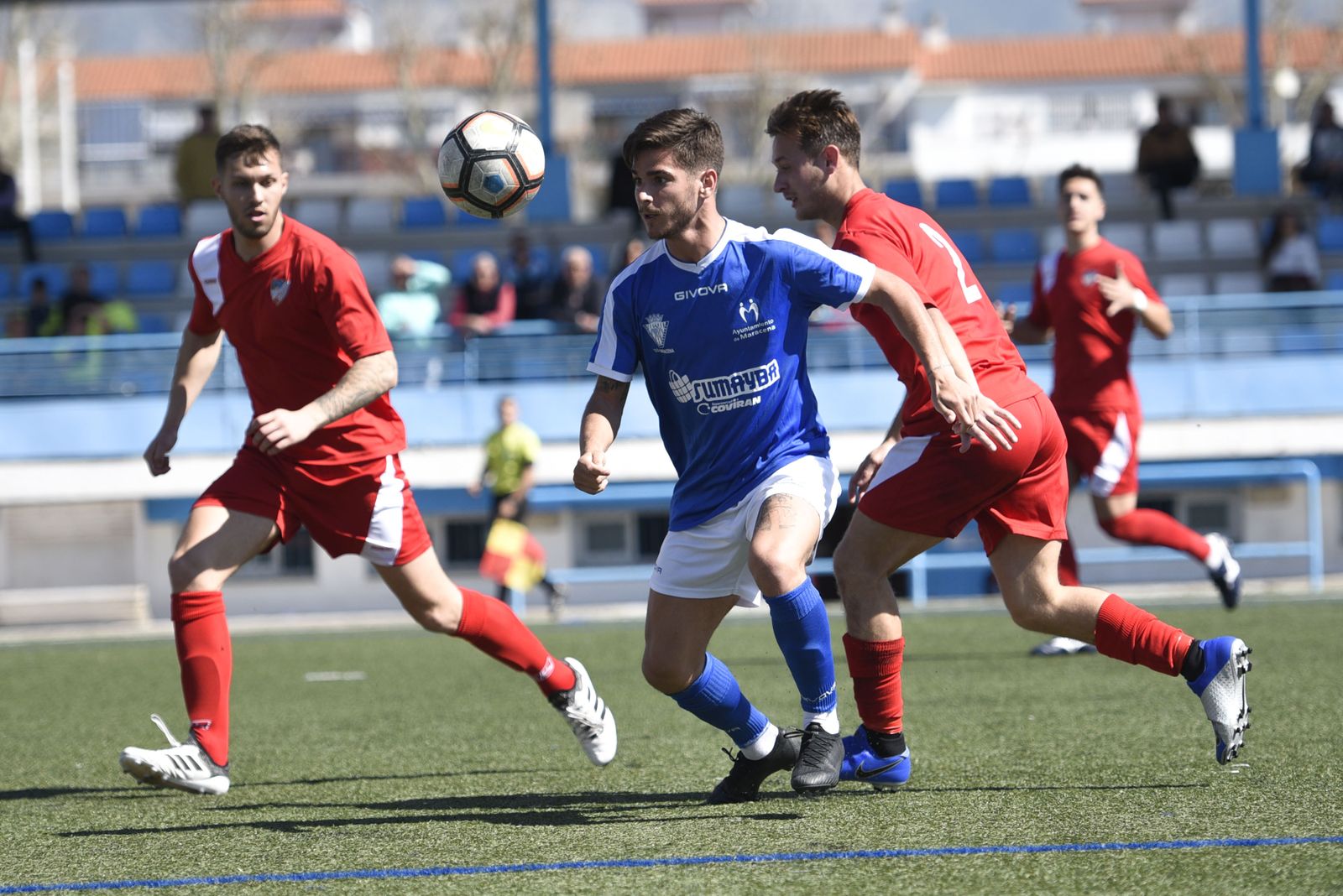 Un jugador del Maracena trata de salir de la presión de dos rivales.