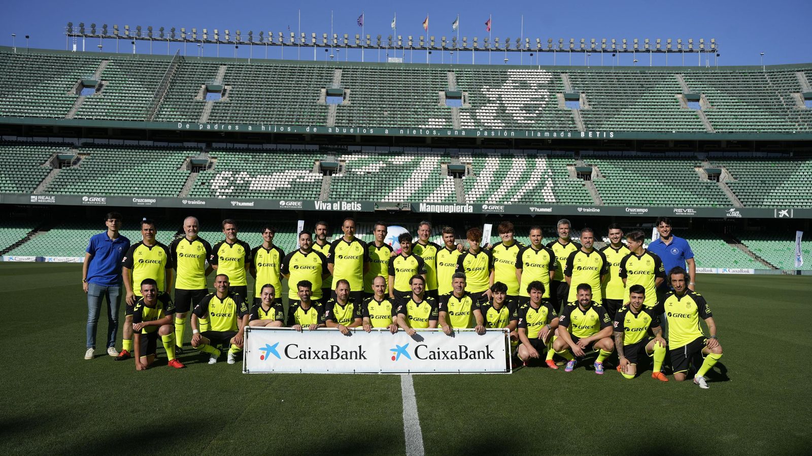 Los jugadores de los dos equipos posan antes del partido con la tribuna de Fondo detrás.