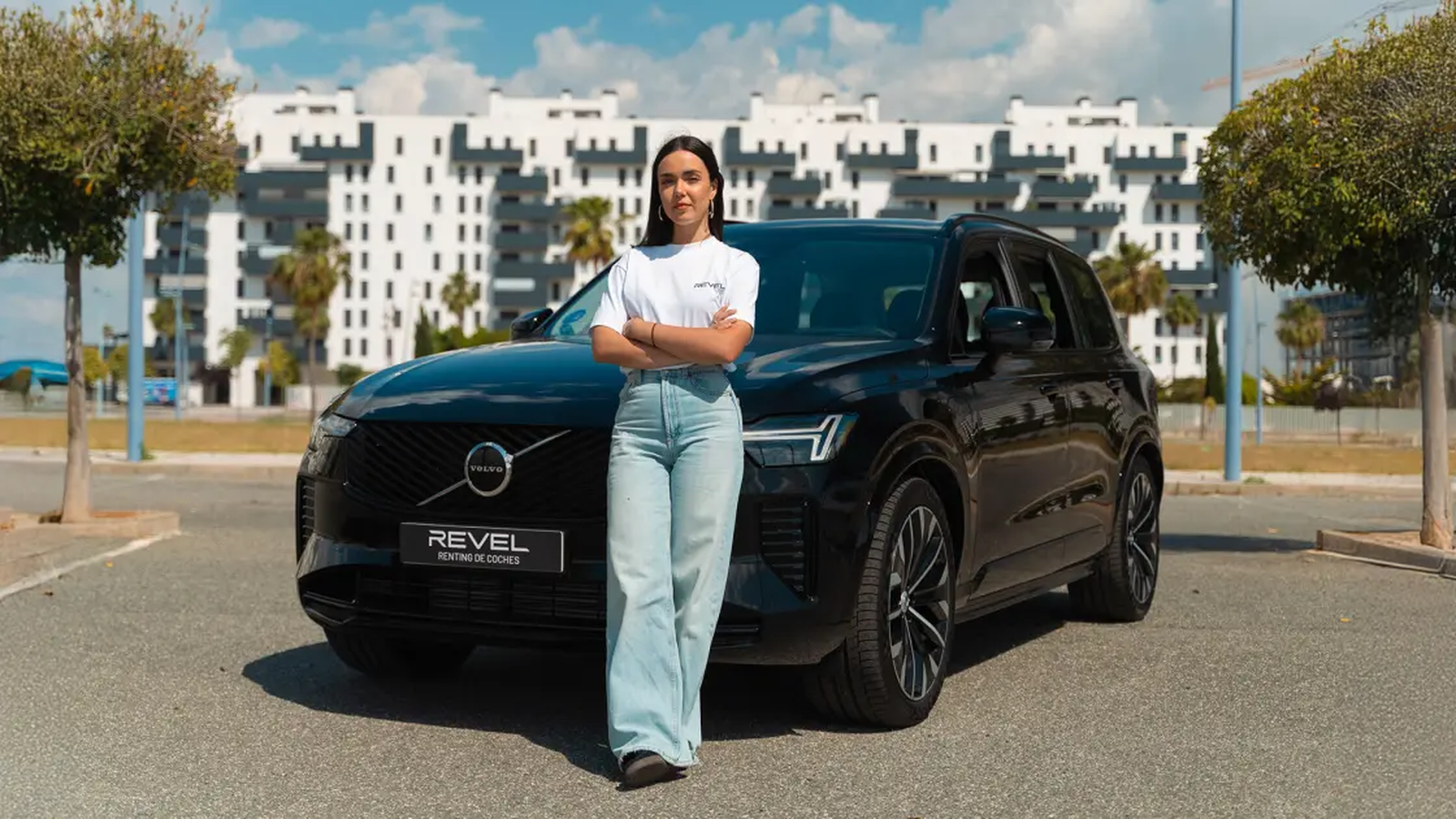 Una mujer posa frente a un coche de Revel.