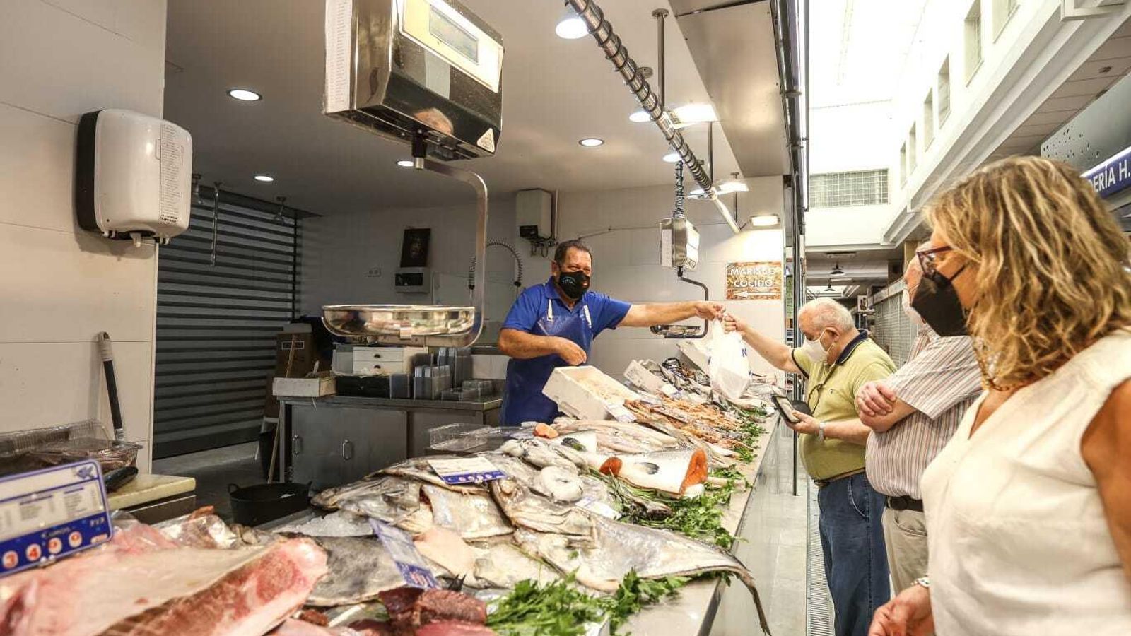 Un pescadero del Mercado Central entrega la compra a un cliente. Un pescadero del Mercado Central entrega la compra a un cliente.