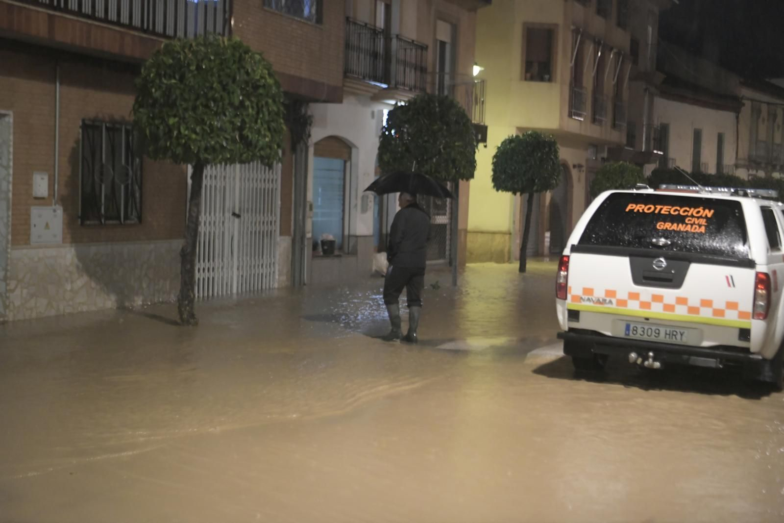 Un viandante junto a un vehículo de Protección Civil en Chauchina Un viandante junto a un vehículo de Protección Civil en Chauchina