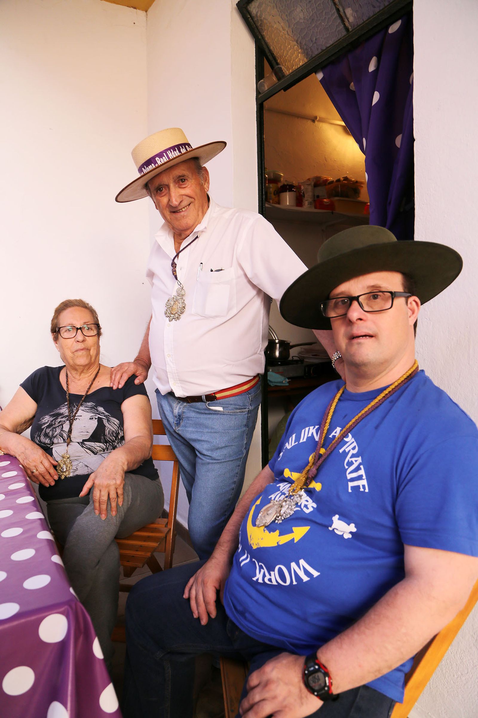 Paco Muñoz junto a su esposa, Loli Lara, y su hijo Raúl, en la puerta de su cuarto de la casa de hermandad.
