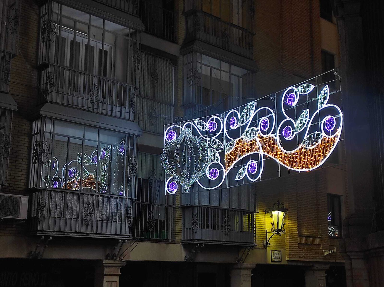 Reflejos de las luces de Navidad en un balcón de la calle Campanas.