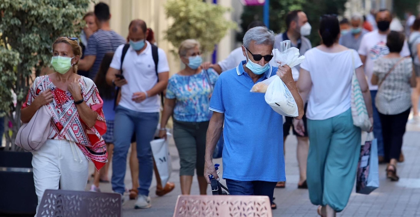 Viandantes protegidos con mascarillas.