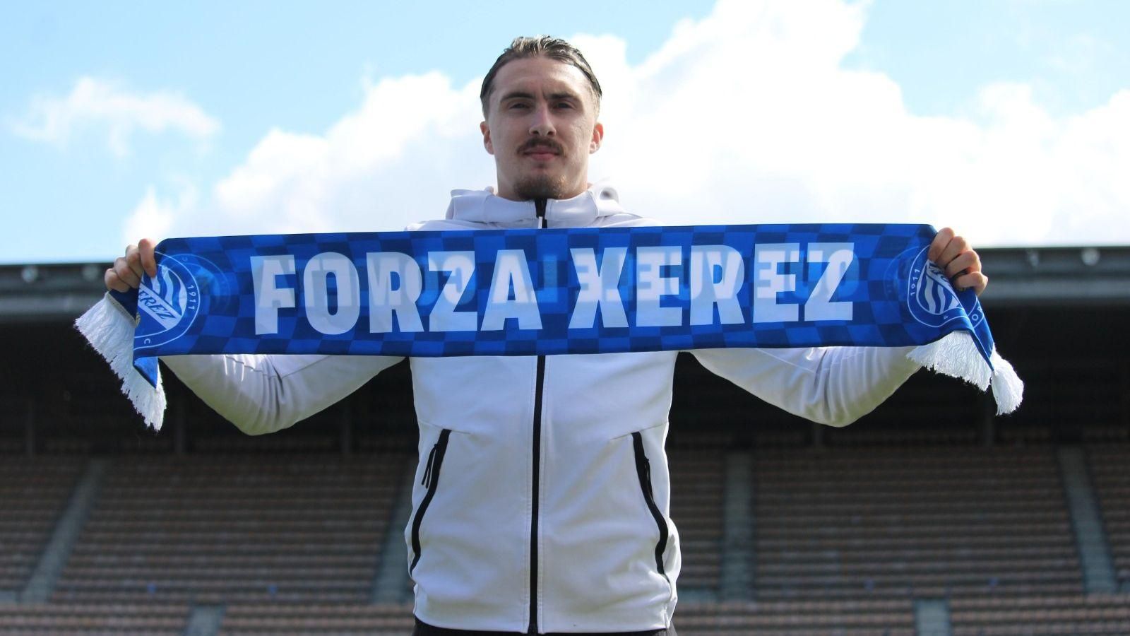 Marlone, con una bufanda del Xerez DFC en el césped de Chapín.
